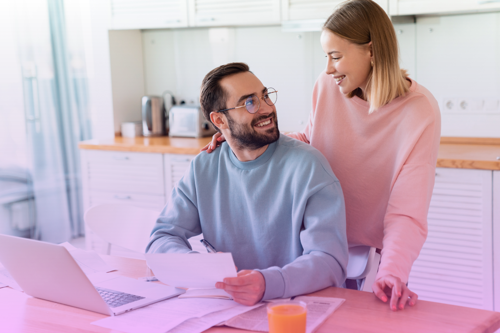 A couple happily holds up a signed legal document, celebrating their decision to get a prenup and the financial clarity it provides.
