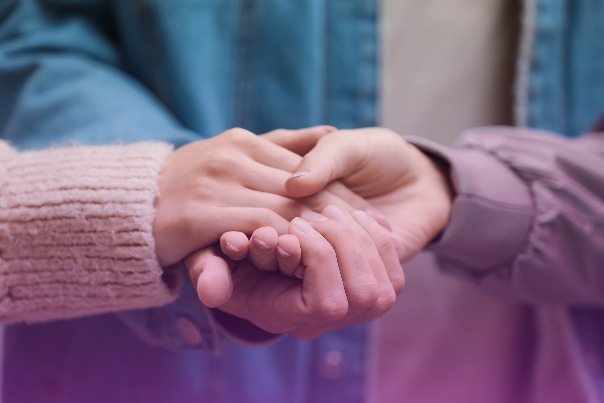 A person holds up a hand to stop their partner from talking, symbolizing the minimization and avoidance of important emotional conversations.