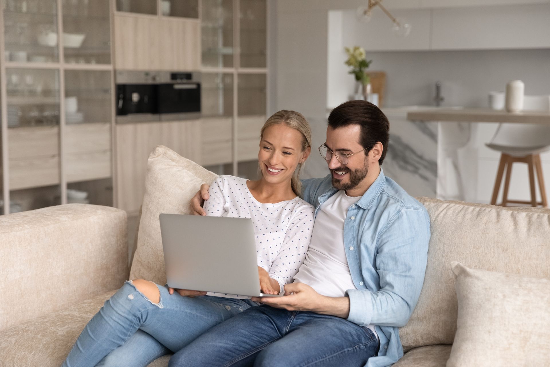 Couple Reviewing Their Online Prenup Together A couple sitting closely together while looking at a laptop screen, appearing focused as they work on their prenuptial agreement online.