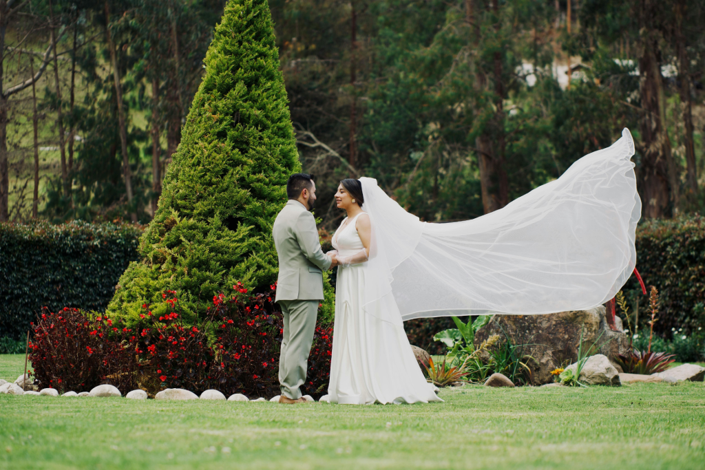 Bride and groom at an outdoor wedding with the bride's veil flowing in the wind