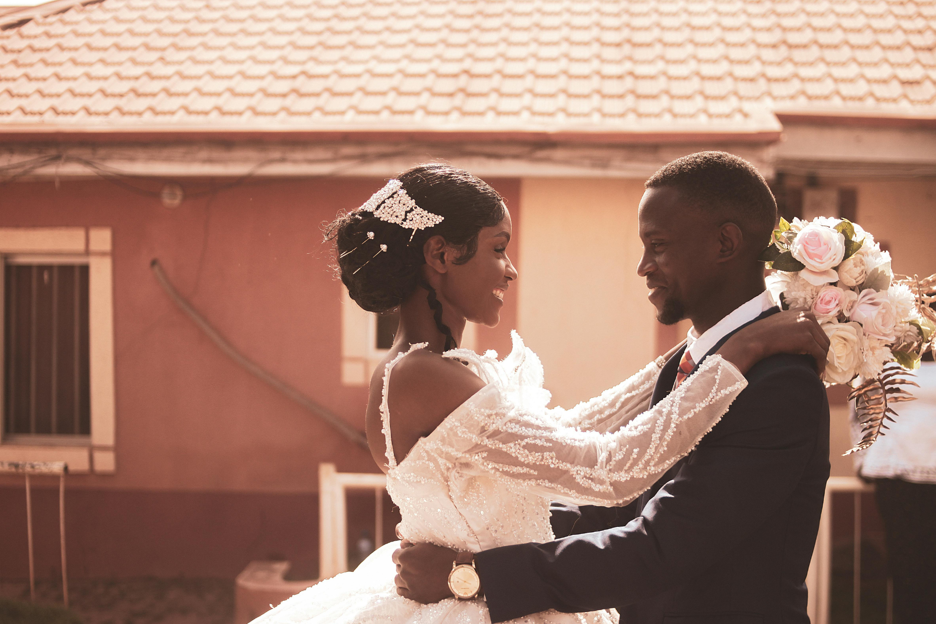 Wedding Couple Gazing at Each Other by the Window A bride and groom standing by a window, looking into each other’s eyes on their wedding day, dressed in their wedding attire.