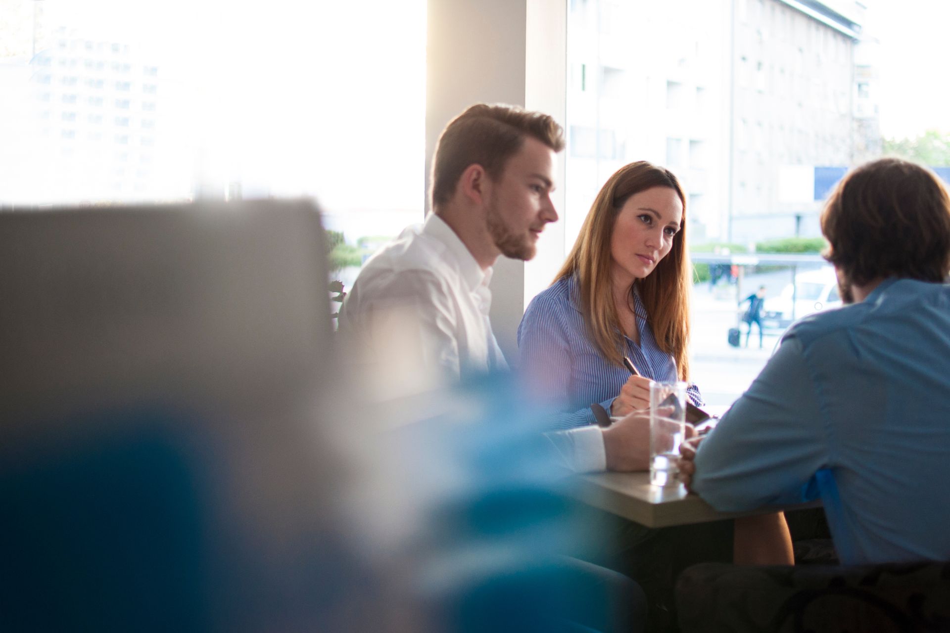 couple-consulting-lawyer-drafting-will couple sitting with their lawyer in an office, discussing details and signing the documents for their legal will.