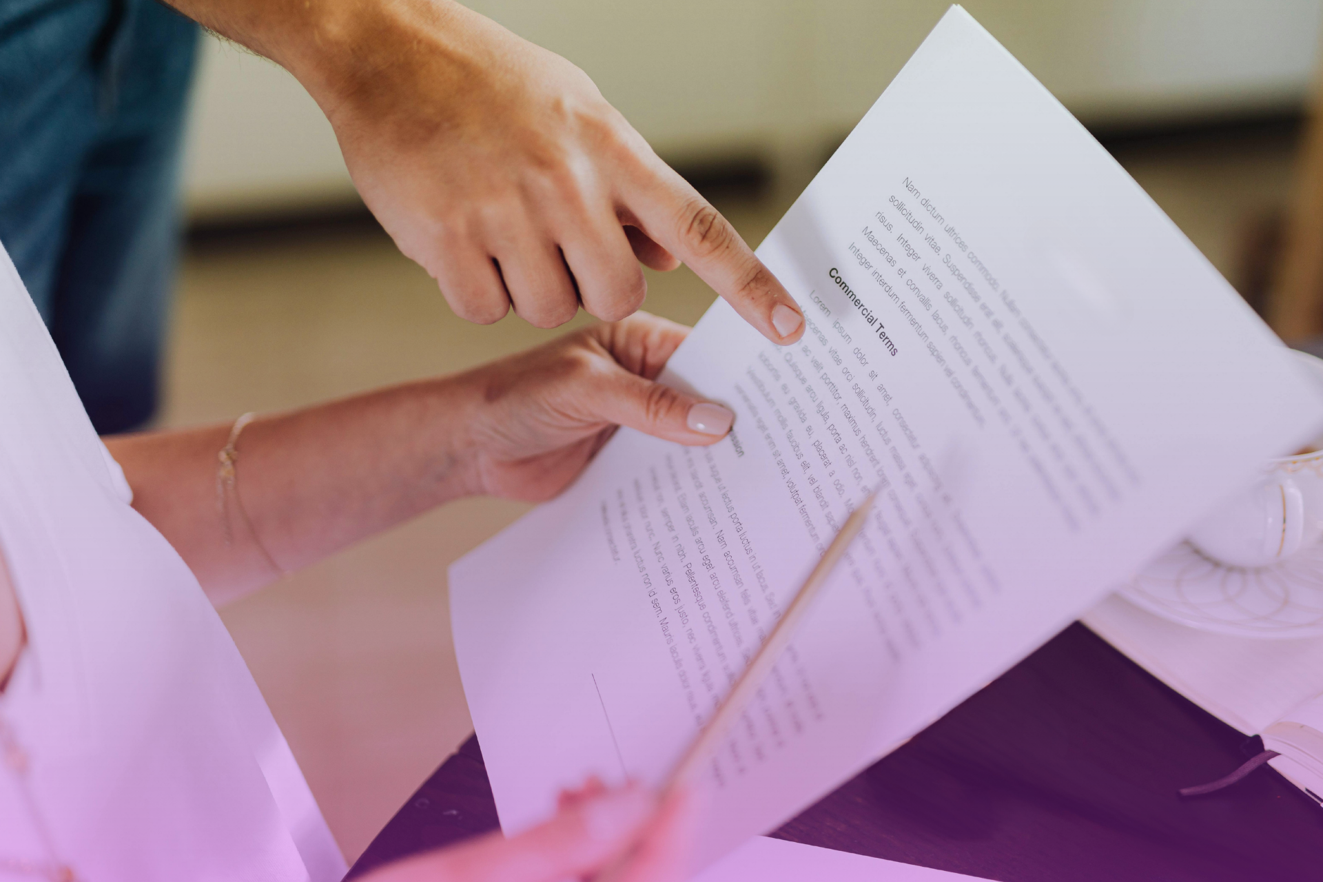 Close-up of hands reviewing the clauses of a North Carolina premarital agreement document with legal notes in the margin.