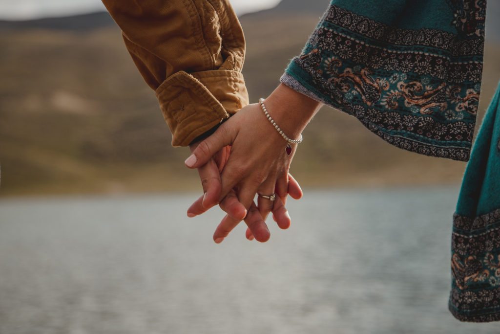 A close-up of a couple holding hands, with only their hands visible
