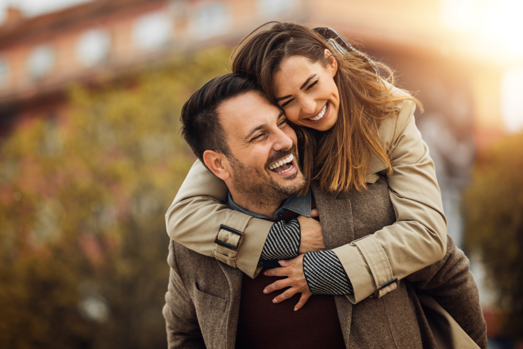 Missouri couple laughing and playing together outdoors on an autumn day after creating their prenuptial agreement