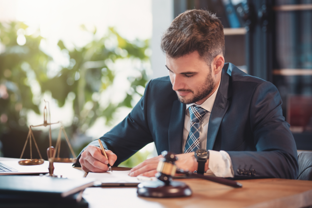 A lawyer sitting at a desk in their office, signing a legal document during a professional work moment