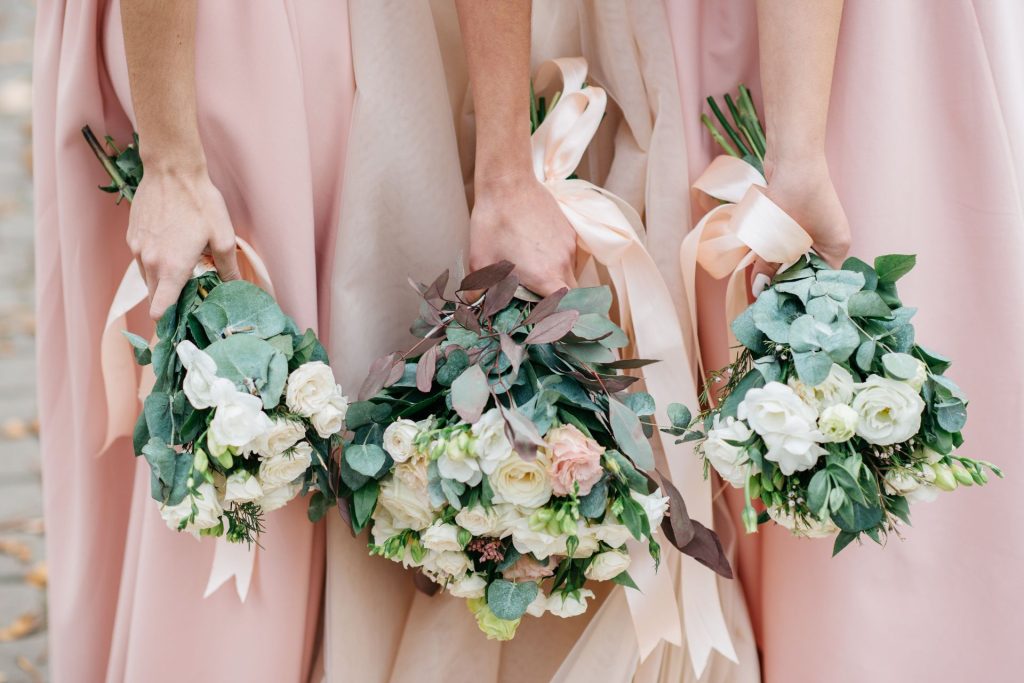 A collection of bridal and bridesmaids bouquets featuring white and light pink flowers, arranged together in a soft and elegant style