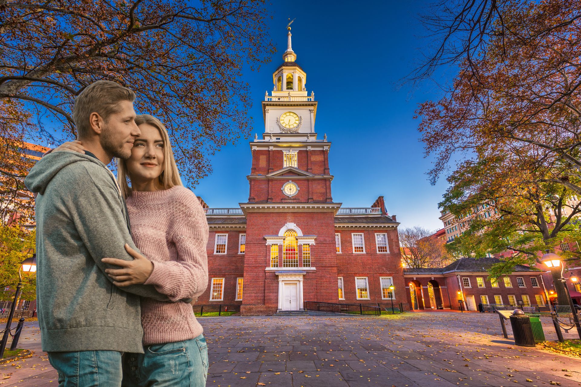 A couple hugging as they look out over the Philadelphia skyline, enjoying a scenic city view together