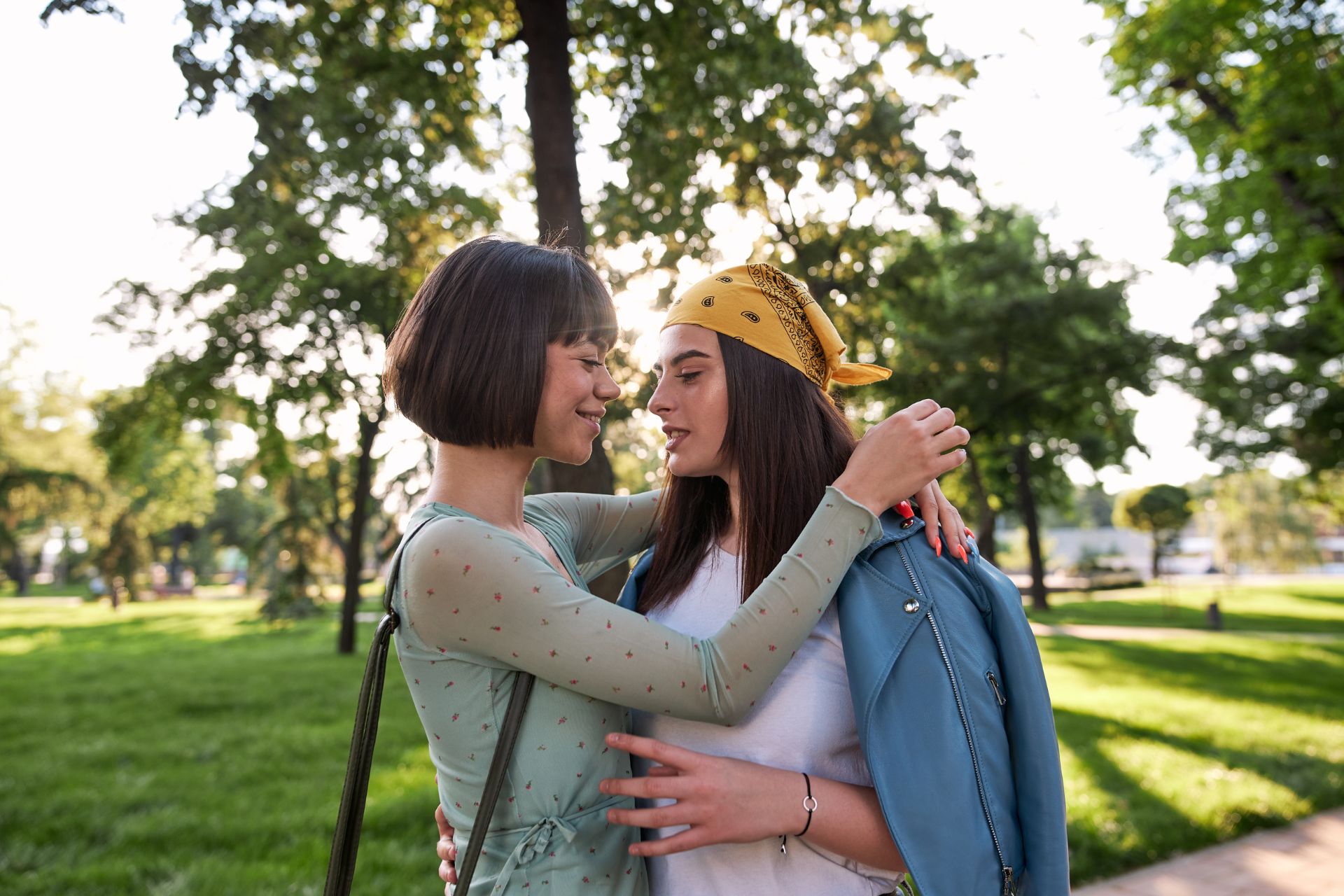 Couple laughing and embracing outdoors A couple hugging and laughing together outside, sharing a joyful moment in a natural outdoor setting