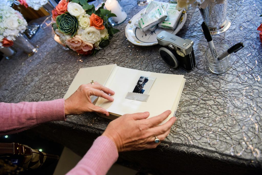 Guests writing messages and signing a wedding guest book during the reception celebration