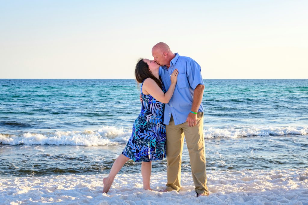 A couple sharing a kiss in front of the sea, enjoying a romantic moment by the water