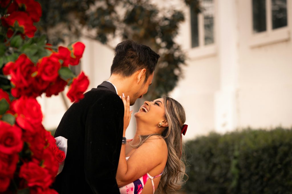 A couple sharing a kiss on a sunny day, enjoying a warm and romantic moment outdoors