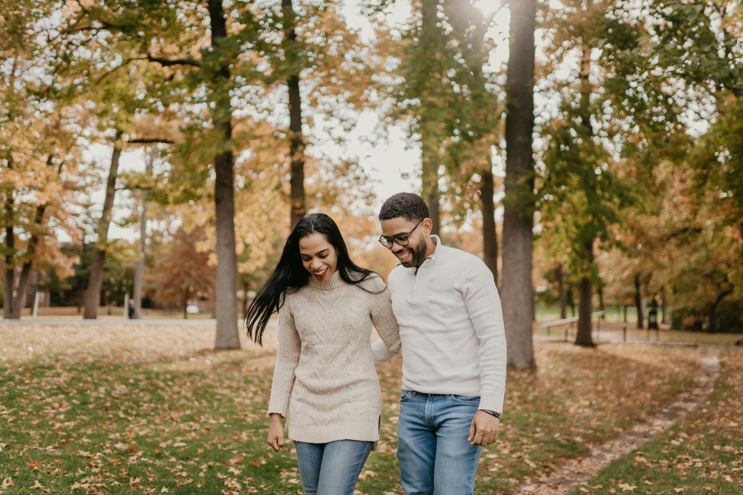 Couple walking through a park in fall A happy couple walking together in a park during autumn, surrounded by fall colors and enjoying a calm, peaceful moment