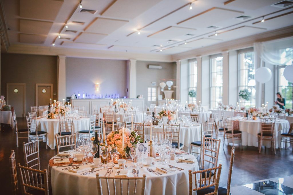 A stunning indoor wedding venue with elegant decor, soft lighting, and a beautifully arranged reception space