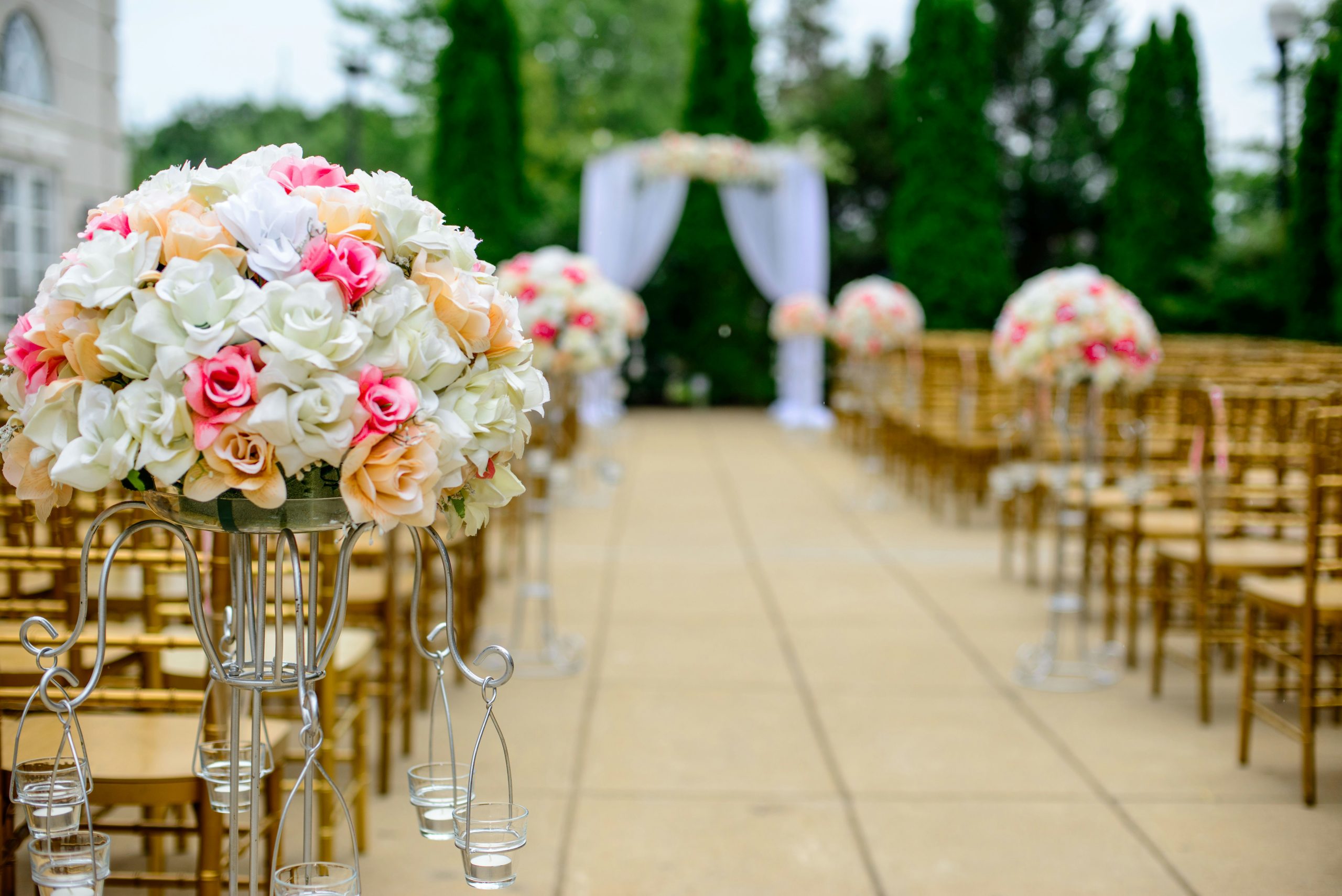 An outdoor wedding venue with rows of chairs arranged facing a decorated altar, set up for the ceremony in a natural setting