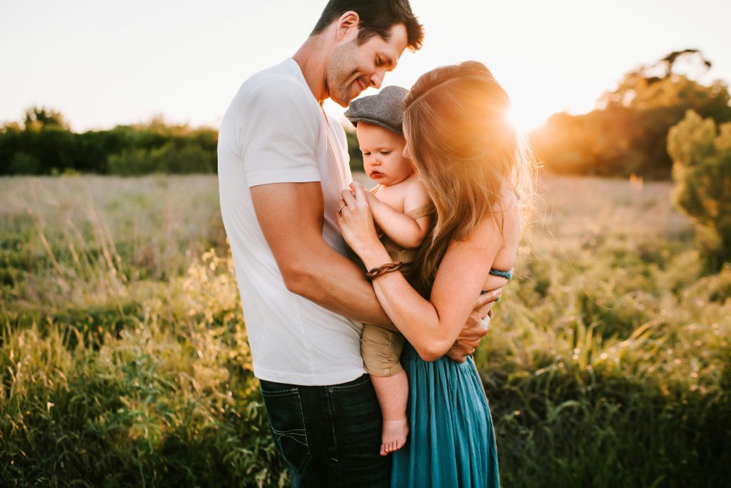 Family embracing in an open sunny field
