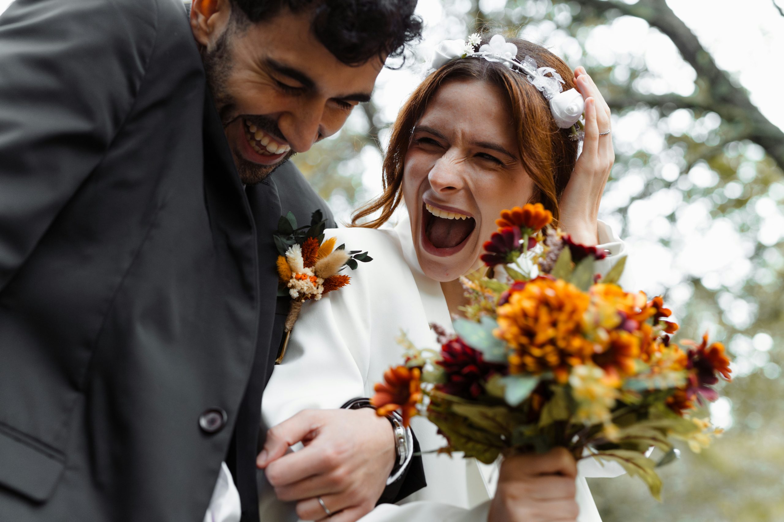 Smiling bride and groom with bouquet A bride holding her bouquet while standing with the groom, both smiling happily on their wedding day