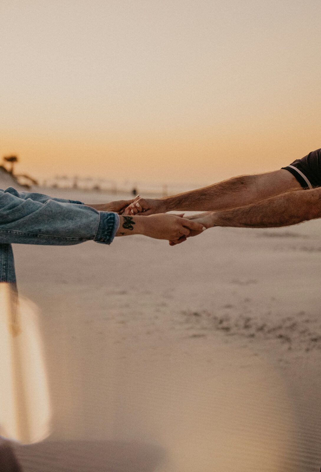 Florida couple holding hands on the beach at sunset after completing their prenup