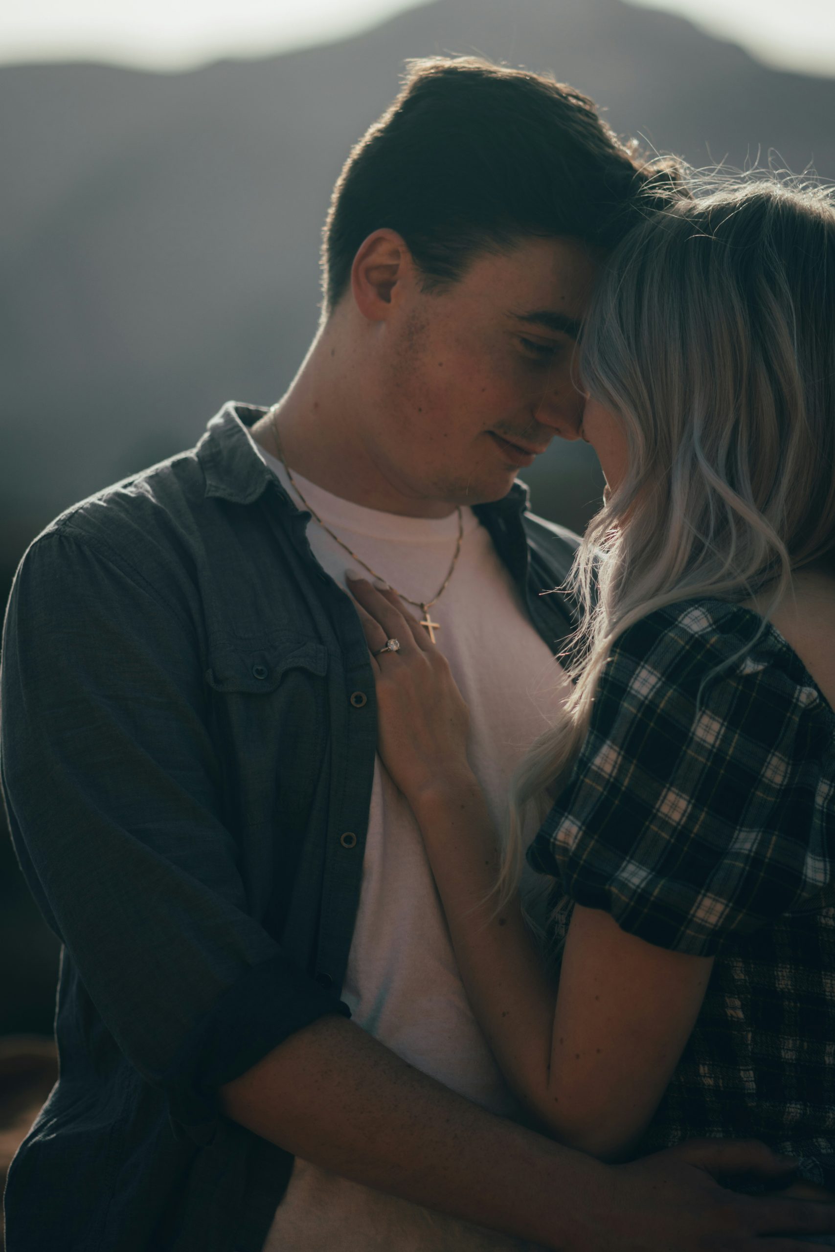Engaged Alabama couple embracing with their engagement ring