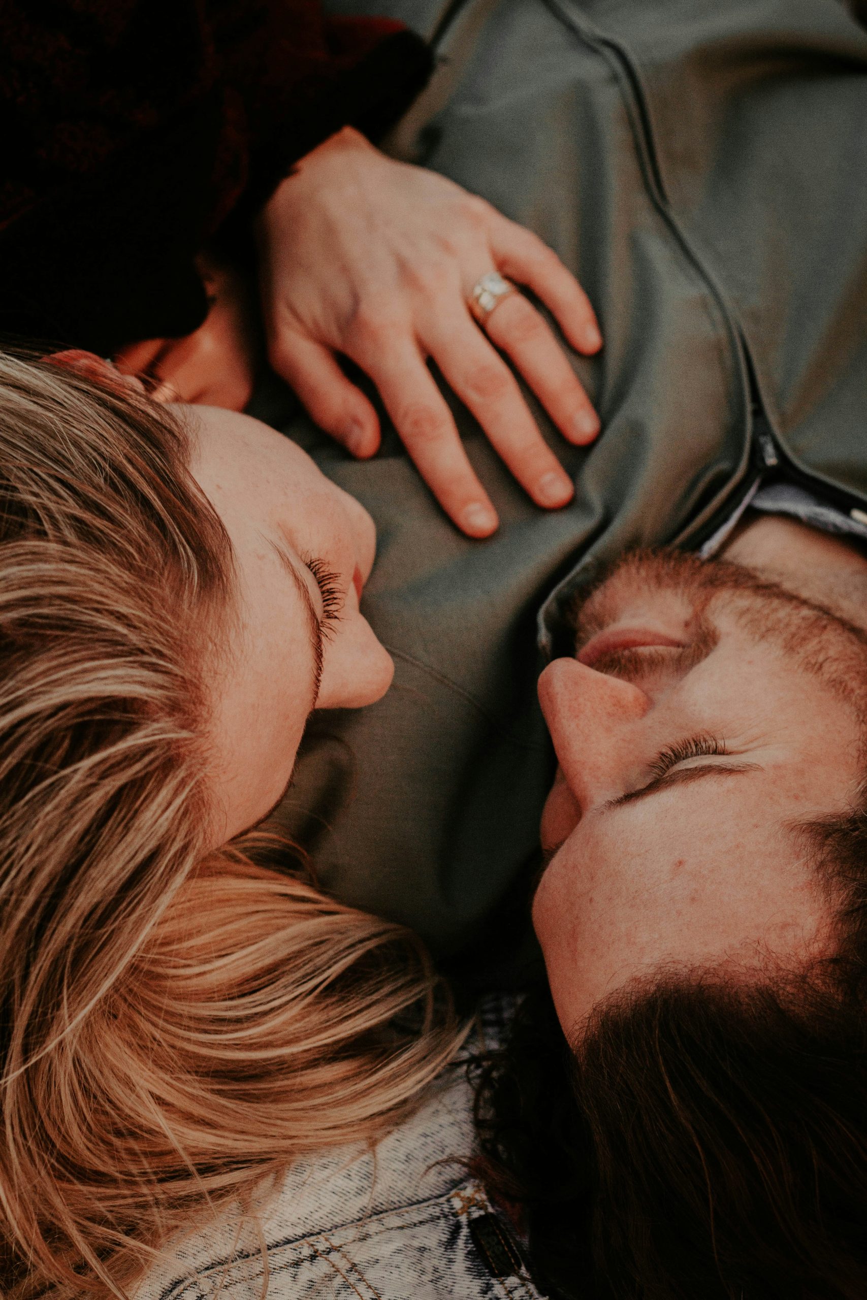 Engaged California couple lying together with an engagement ring, preparing to build their prenup