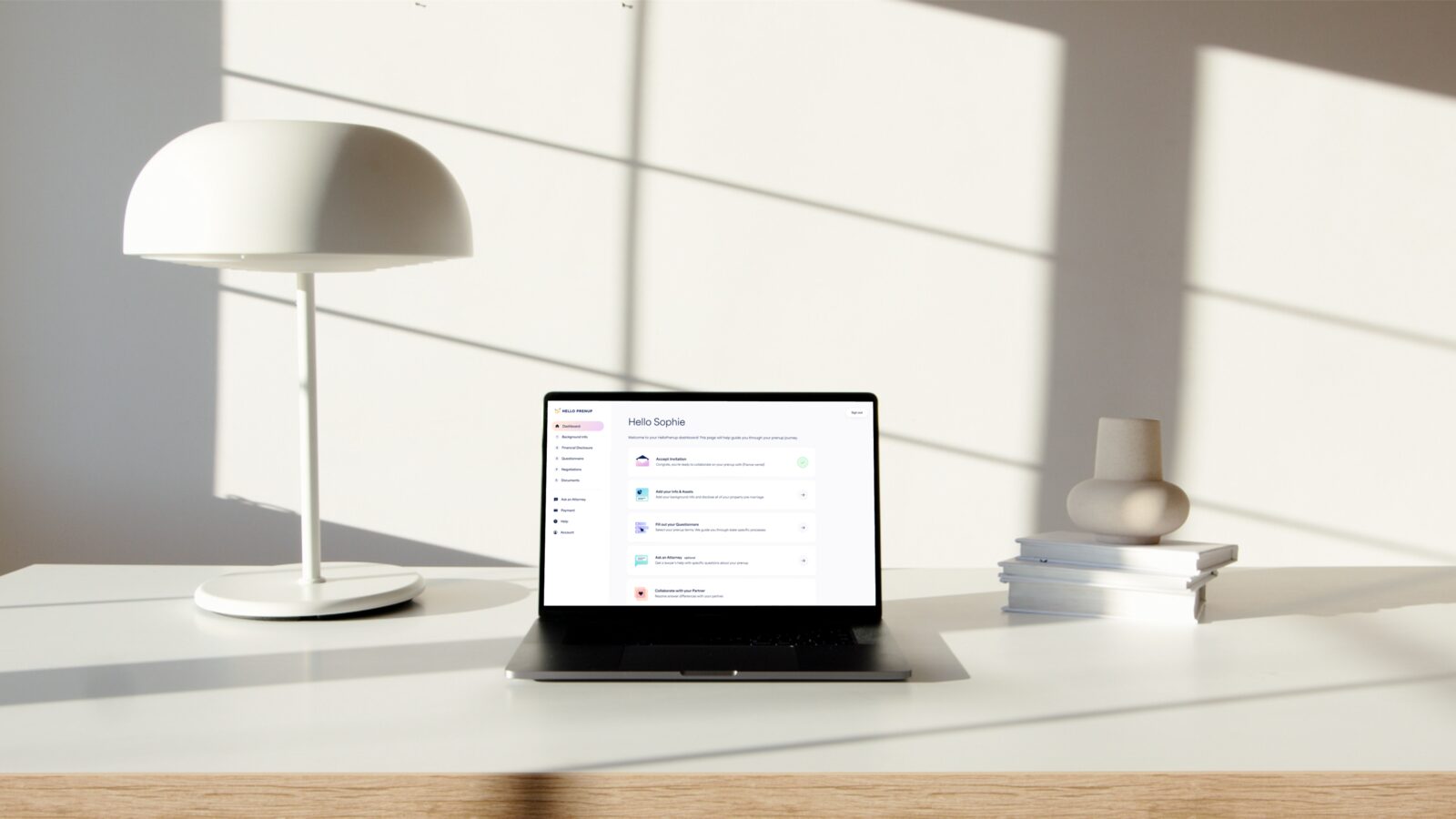 HelloPrenup dashboard on a MacBook Pro at a minimalist desk with a lamp, ready to start an online prenup