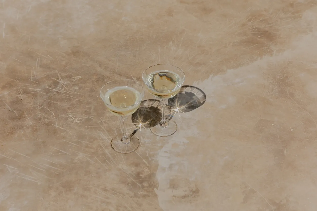 Two champagne coupes on a stone surface, a celebration still life