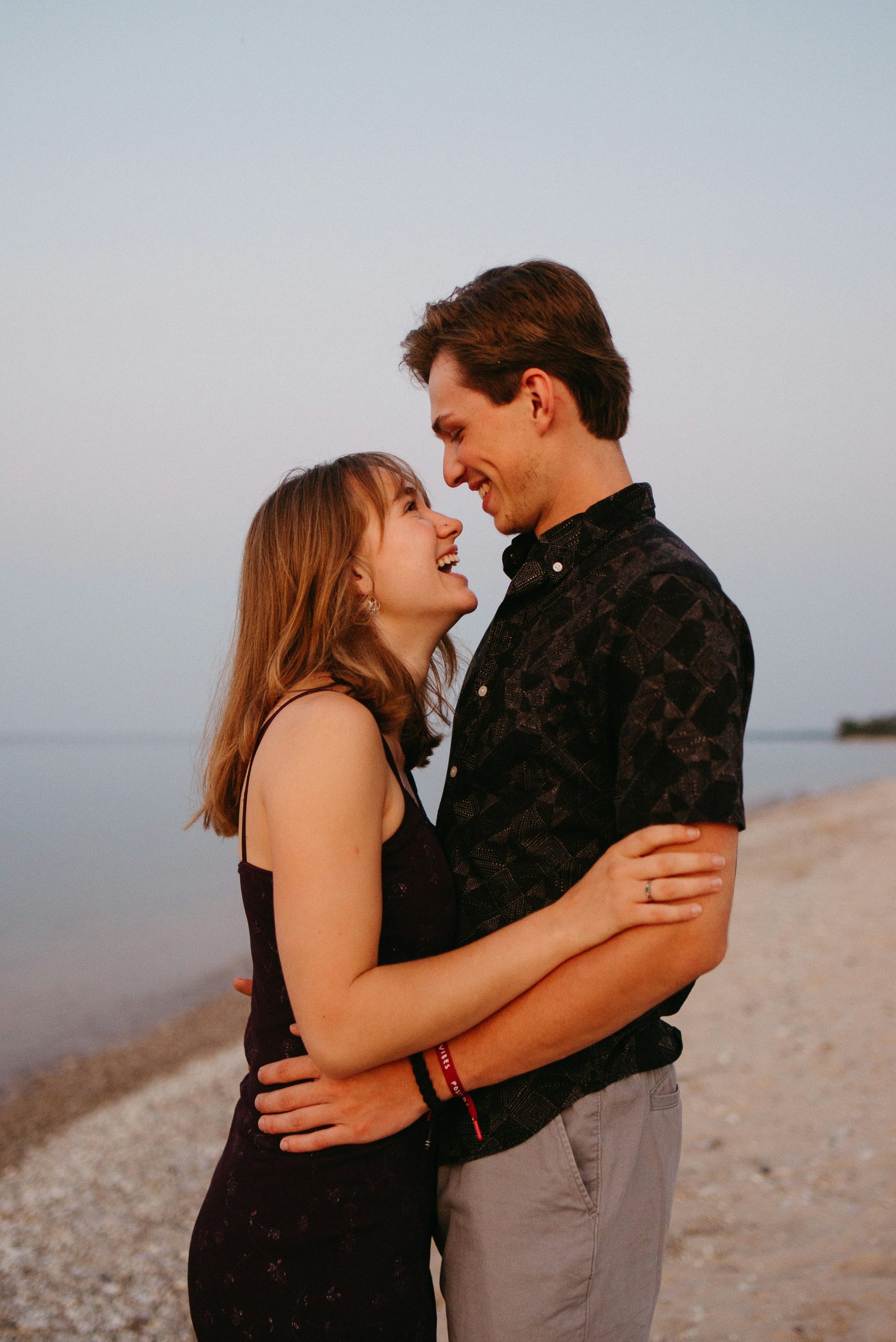 Engaged Alabama couple walking on the beach at sunset, ready to start their HelloPrenup prenuptial agreement