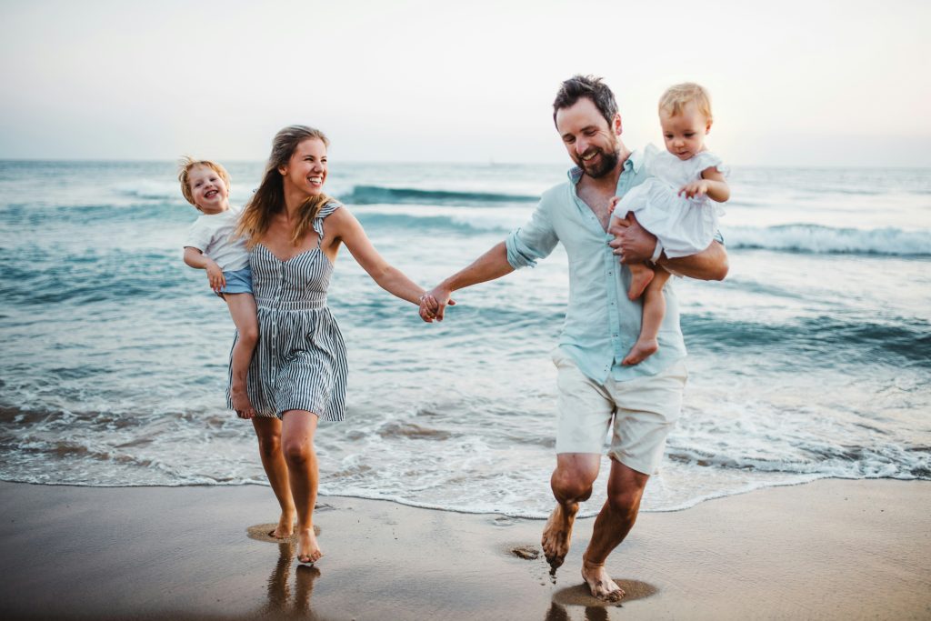 A family spending time together in the water, smiling and laughing as they play in the ocean on a beautiful day