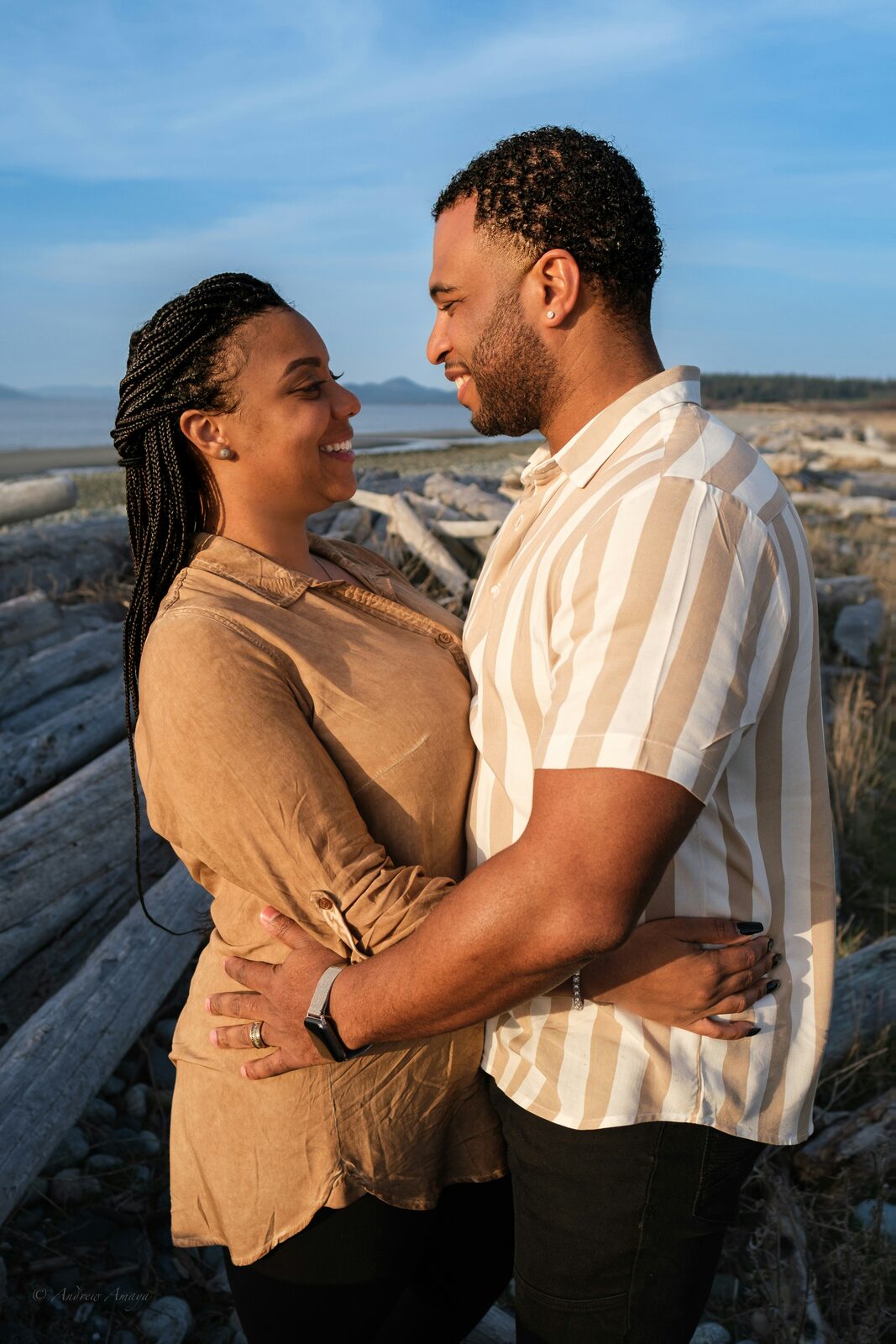 Washington couple embracing on a Pacific Northwest driftwood beach, protected with a HelloPrenup prenuptial agreement