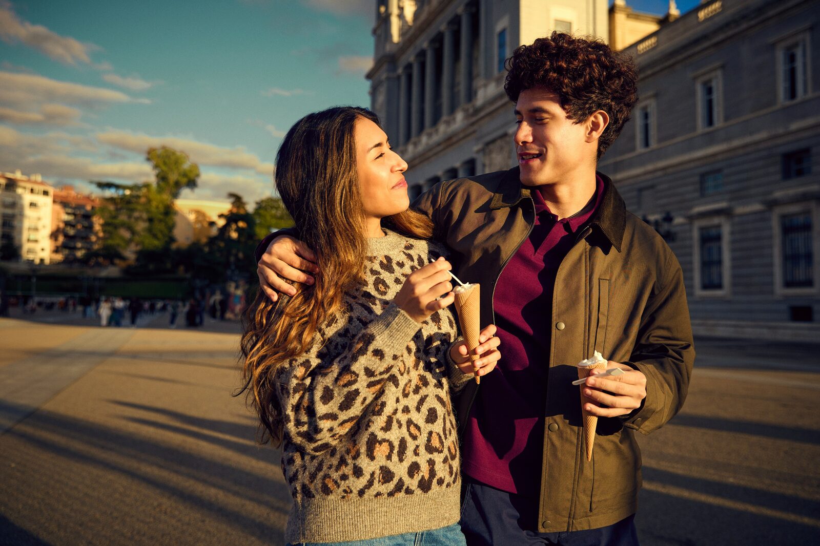 Illinois couple eating ice cream cones at golden hour near a Madrid palace, exploring their prenup options with HelloPrenup