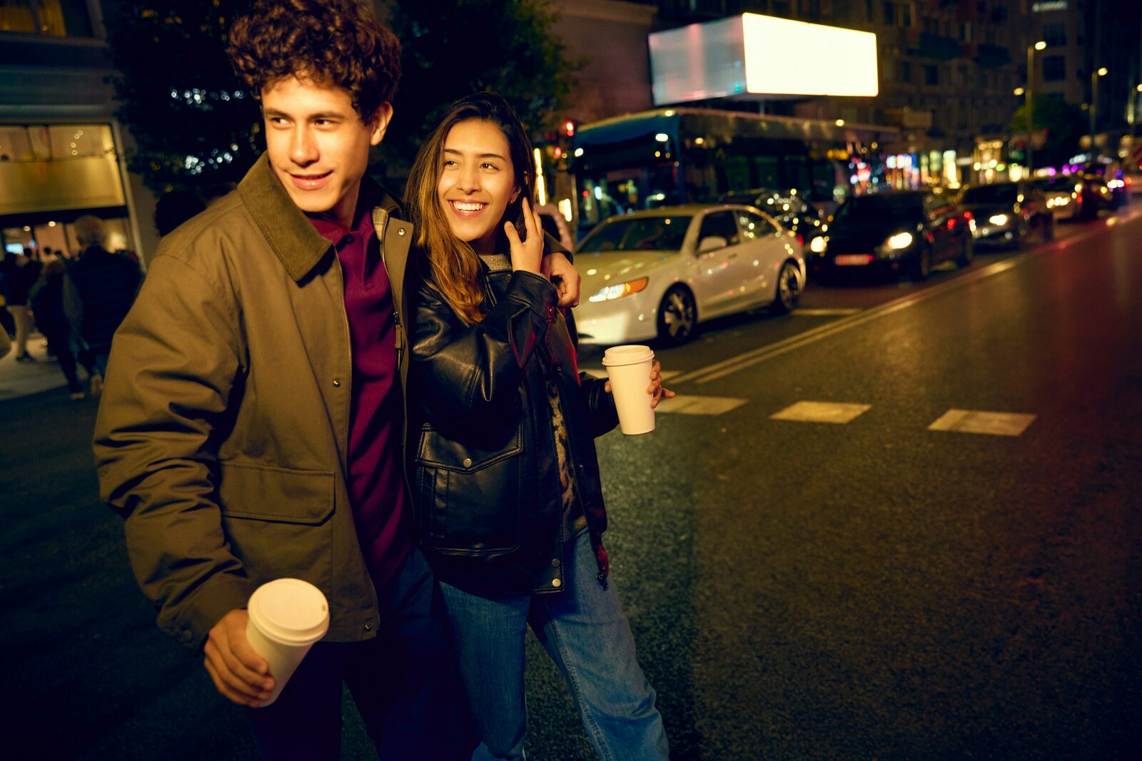 Pennsylvania couple walking through the city with coffee, talking about finances