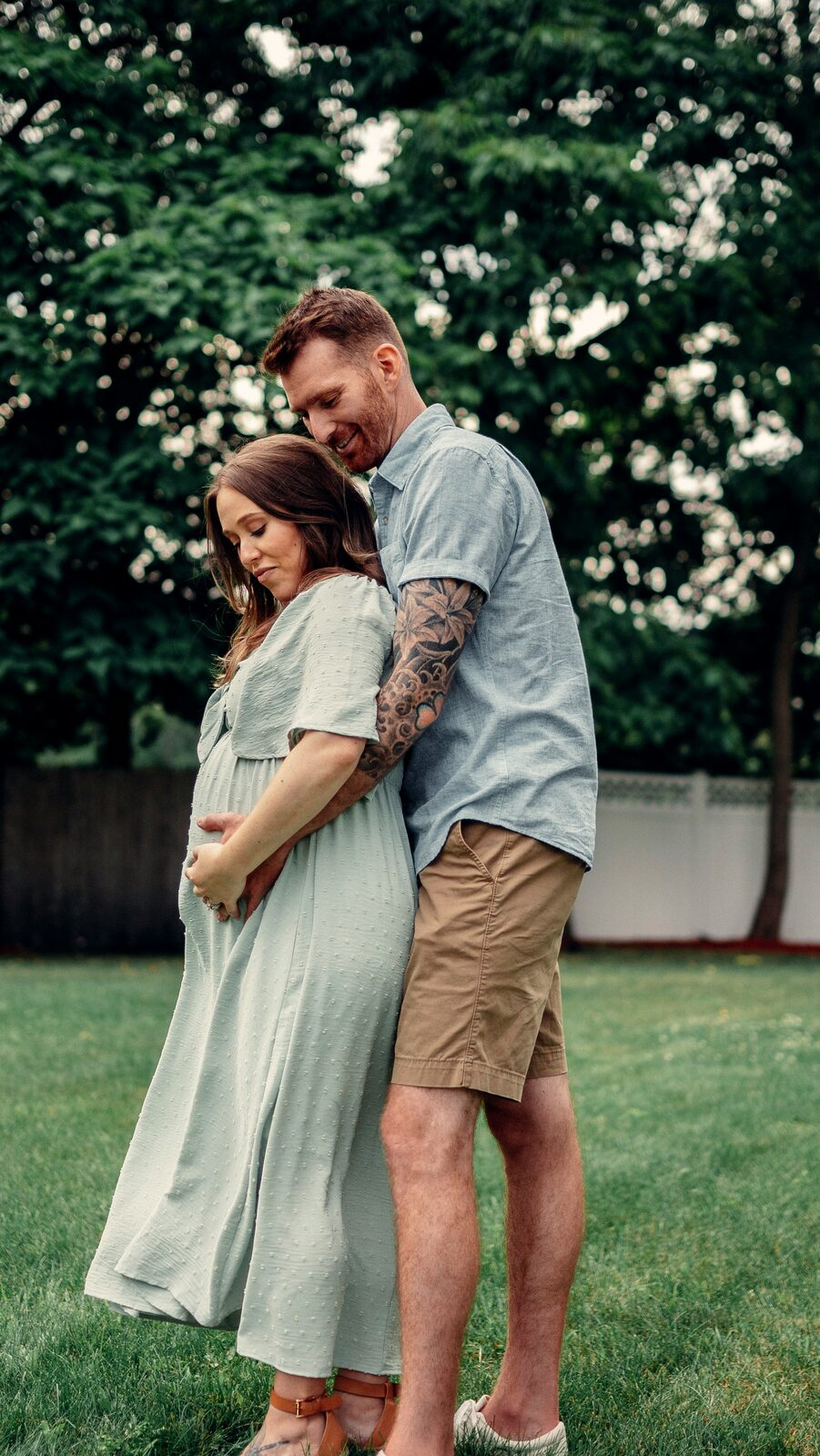 Expecting Massachusetts couple sharing a candid backyard moment after completing their prenup