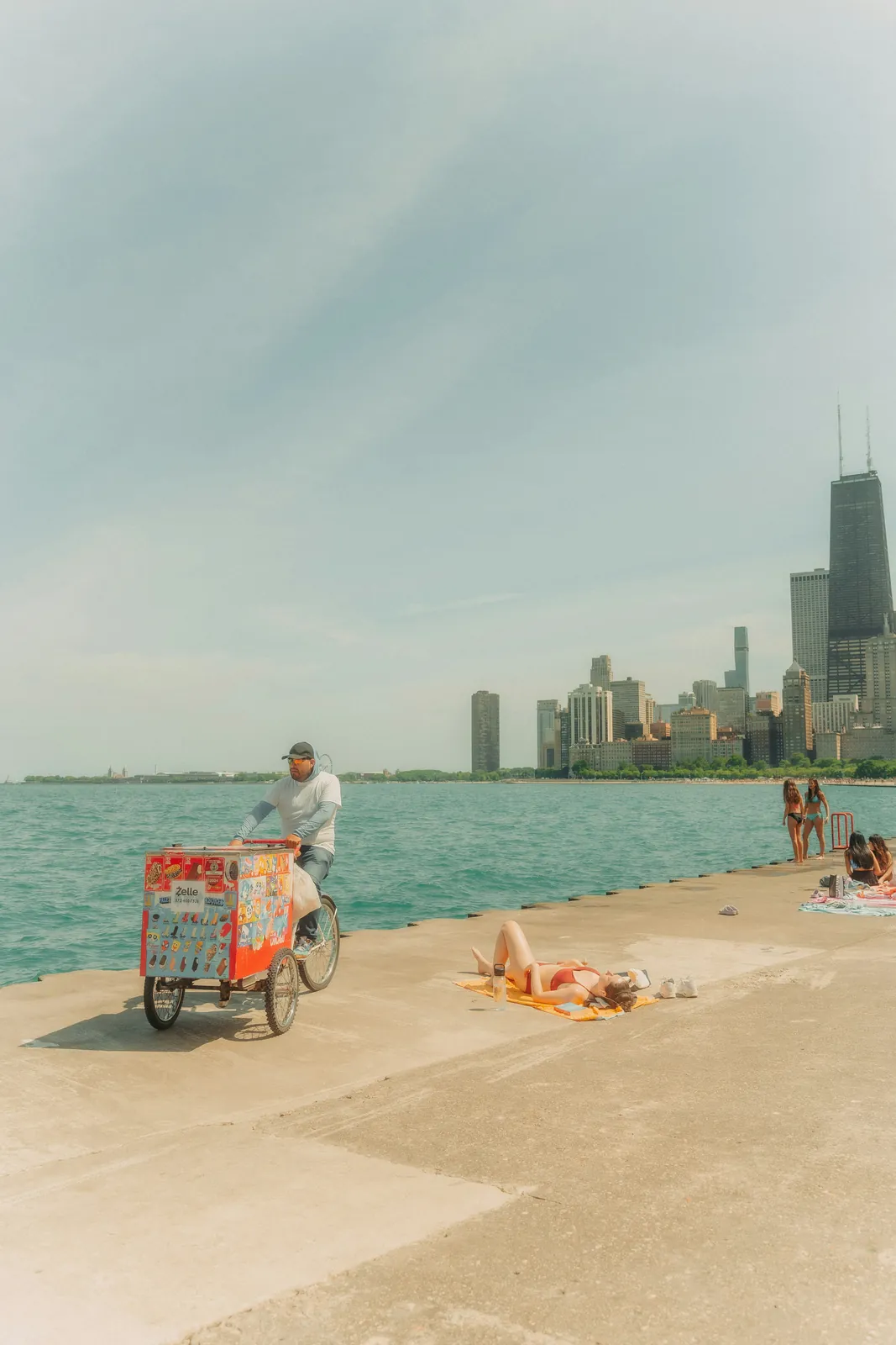 Ice cream vendor on a bike along the Chicago waterfront with the city skyline on a summer day, where Illinois couples start their marriage on the same page with HelloPrenup