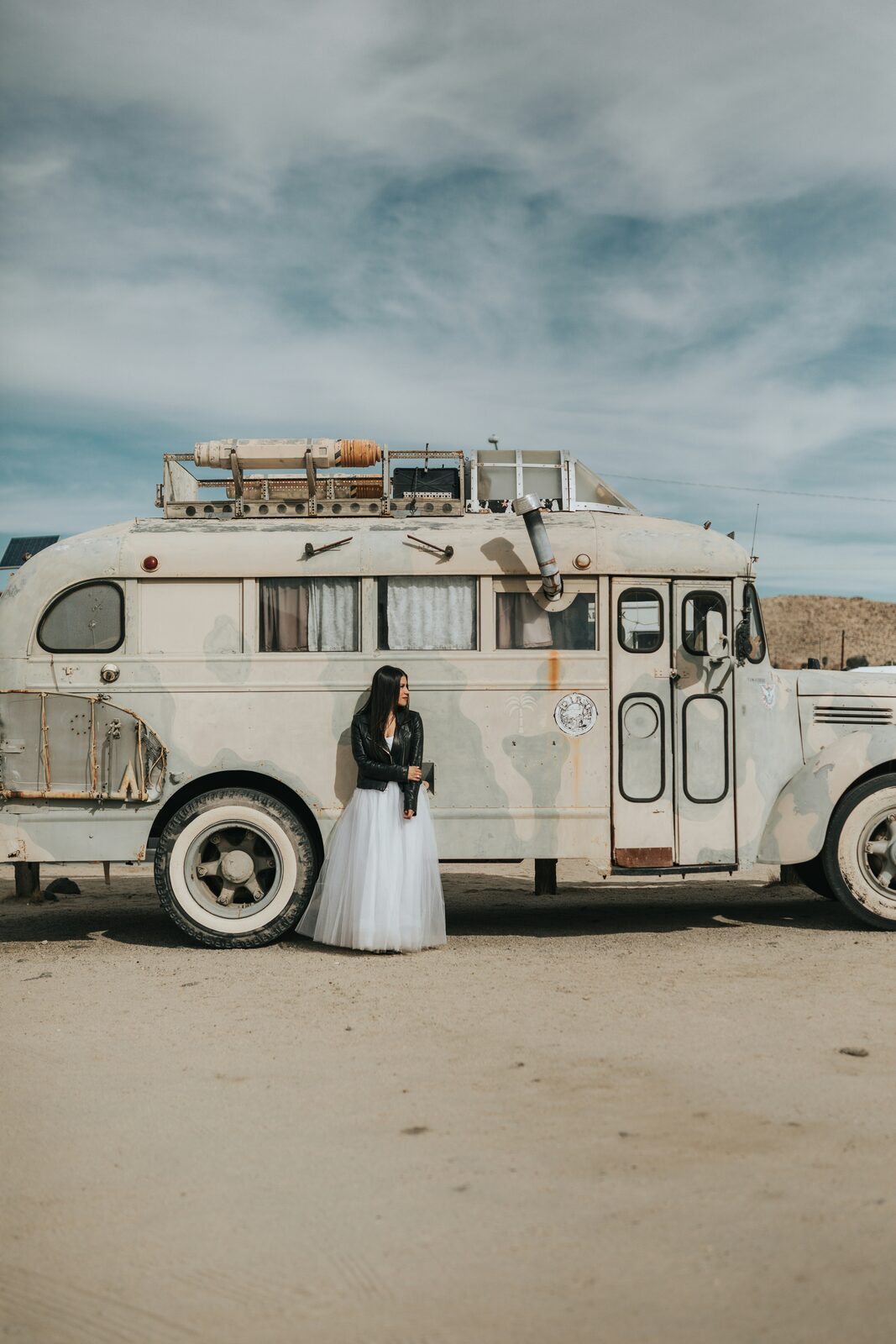 Bride in a tulle skirt and leather jacket in the desert after completing her prenup
