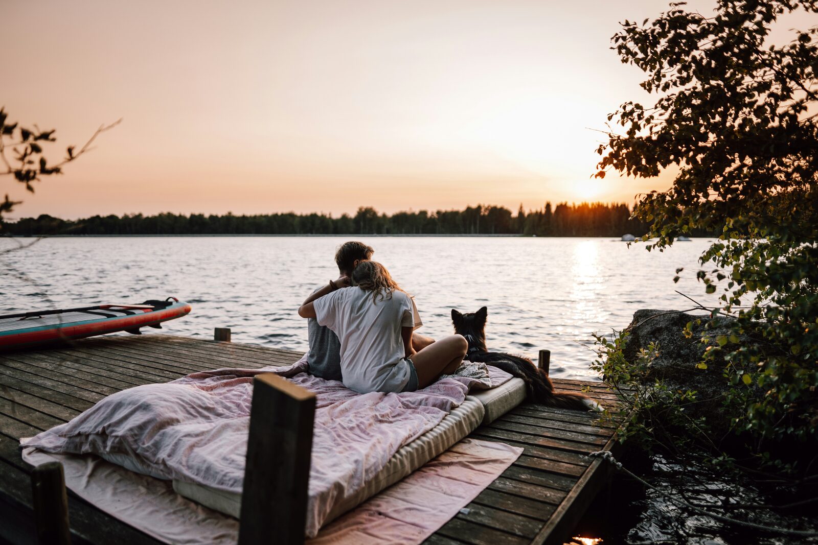 Georgia couple with their dog on a lake dock at sunset
