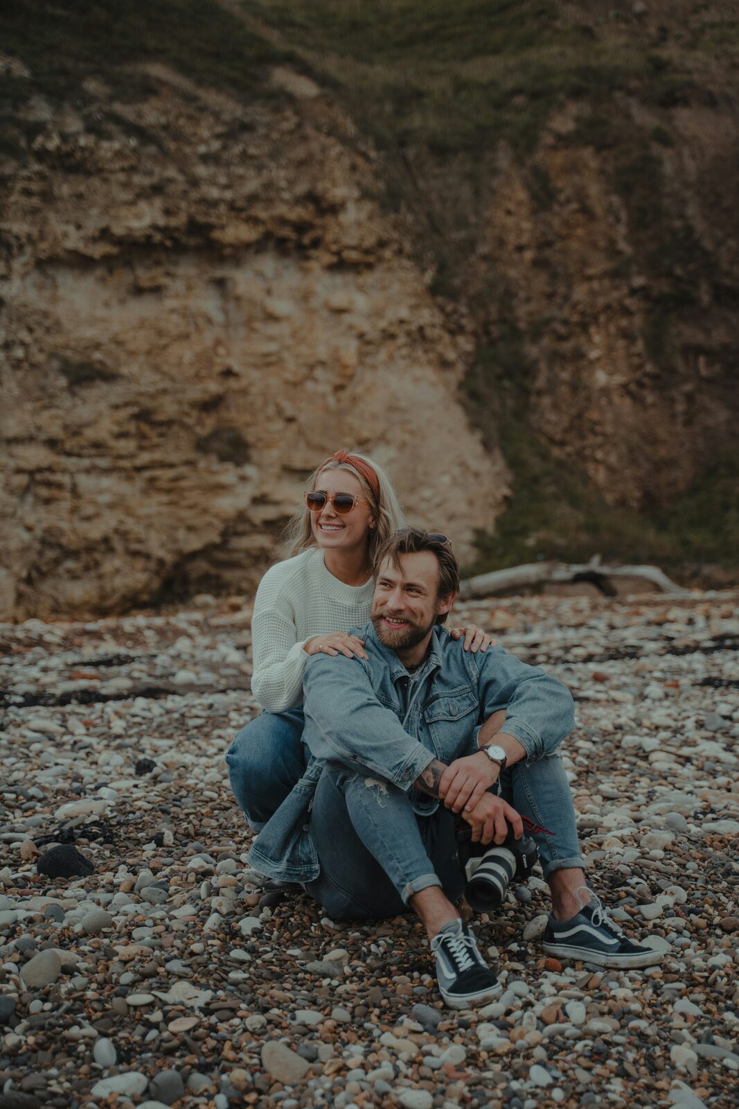 West Virginia couple sitting on rocky beach cliffs, protected with a HelloPrenup prenuptial agreement