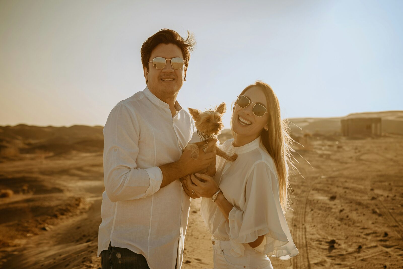 Engaged Georgia couple with their dog in matching white outfits, celebrating their engagement