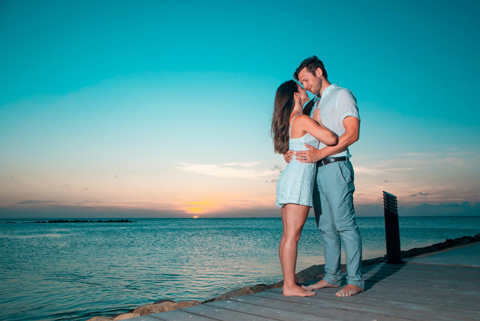 New Jersey couple kissing on a pier at sunset