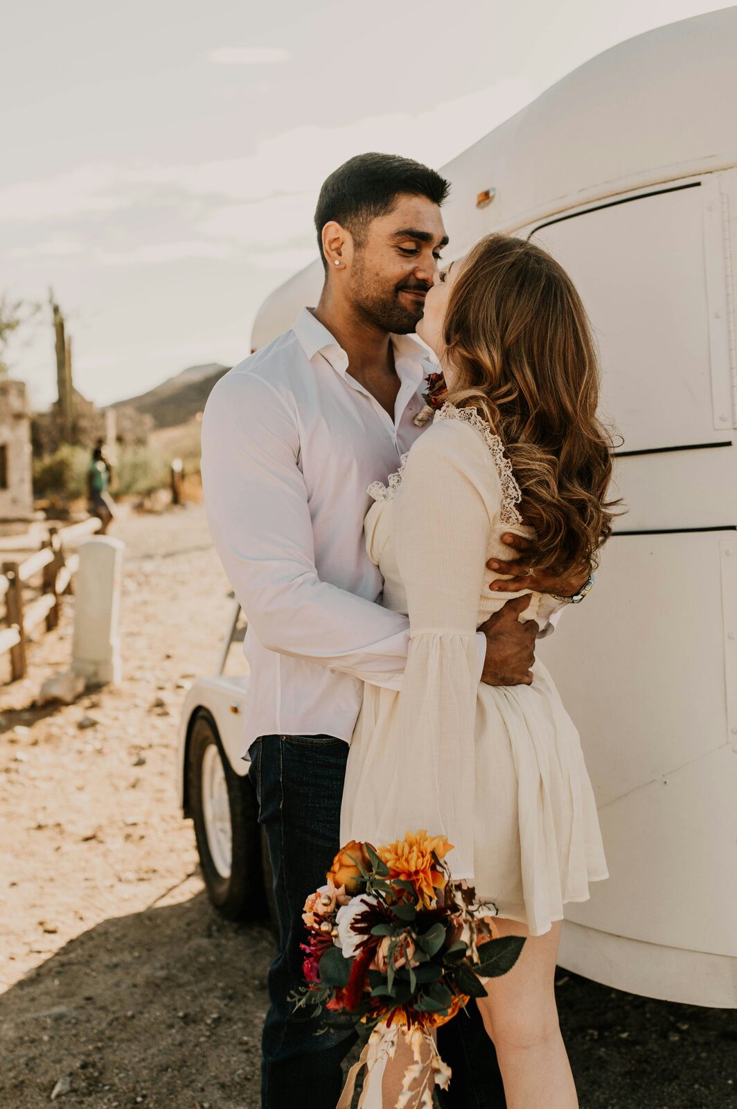 Interracial Arizona couple embracing by a white desert trailer while learning how prenups are enforced