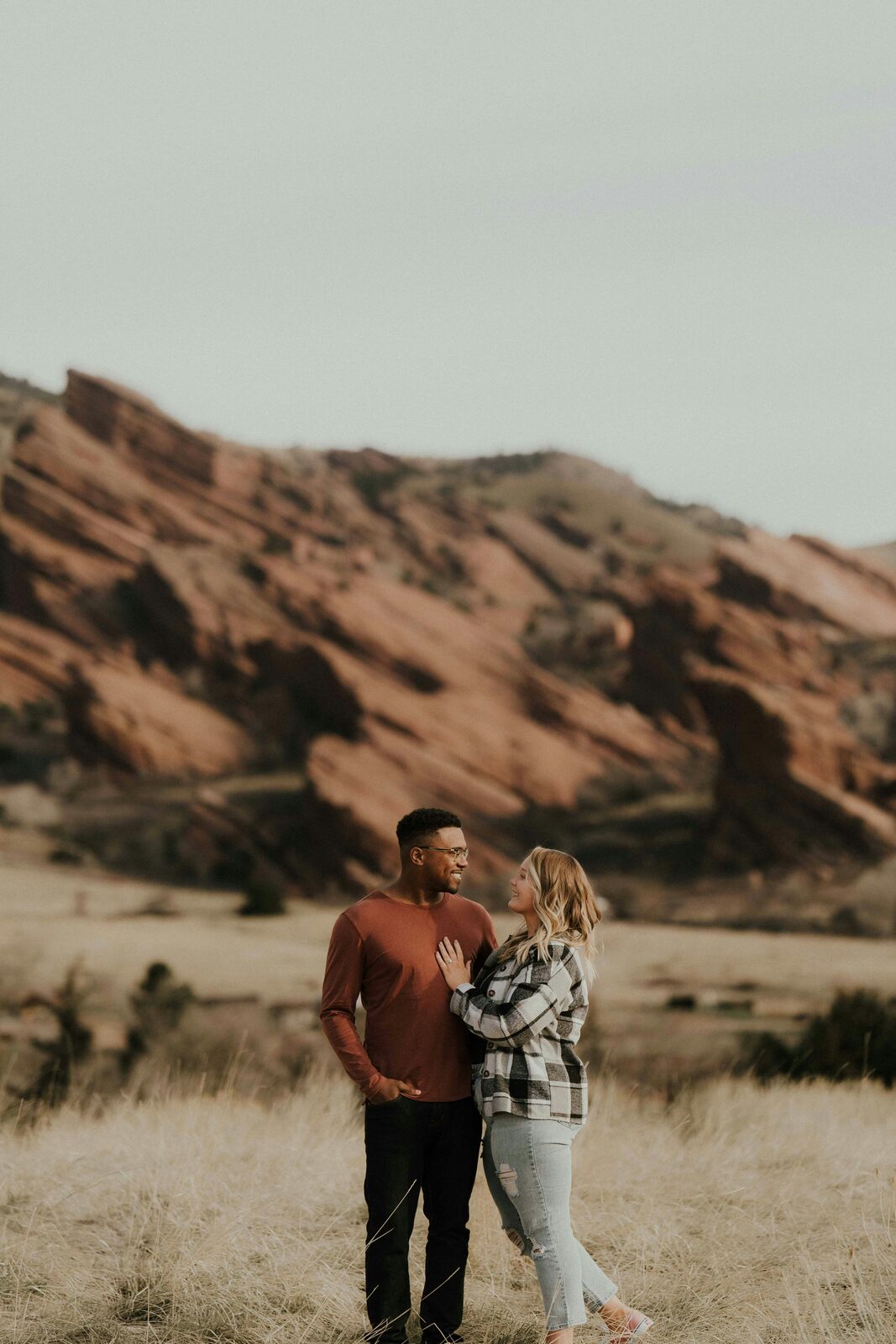 Engaged Colorado couple in a fall portrait at the Red Rocks, protected with a HelloPrenup prenuptial agreement