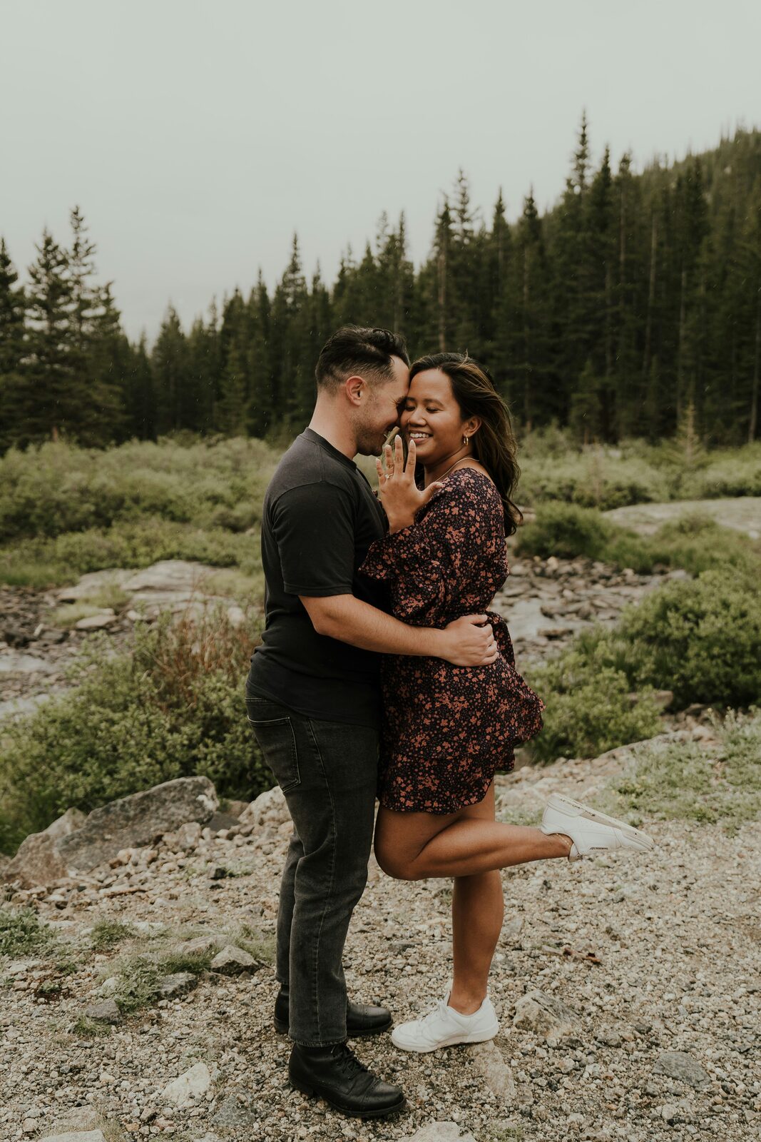 Just-engaged Colorado couple in the mountains showing off the ring after a proposal