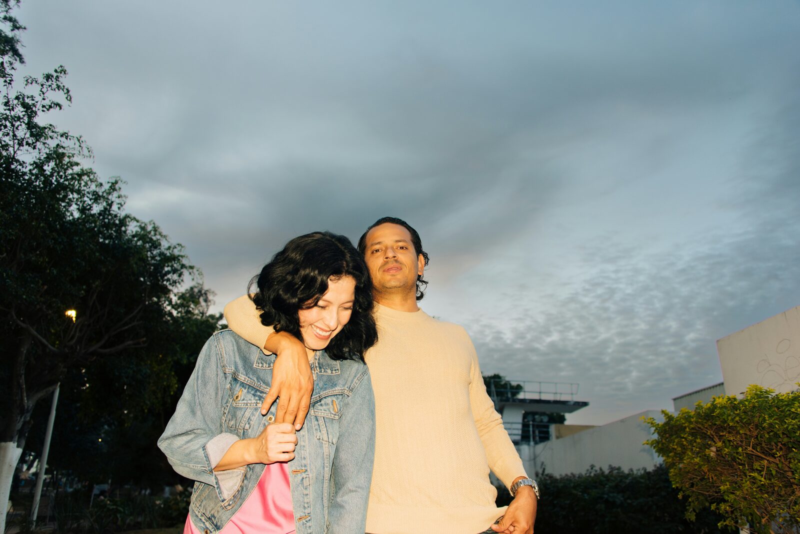 Virginia couple embracing at sunset in a denim jacket and cream sweater