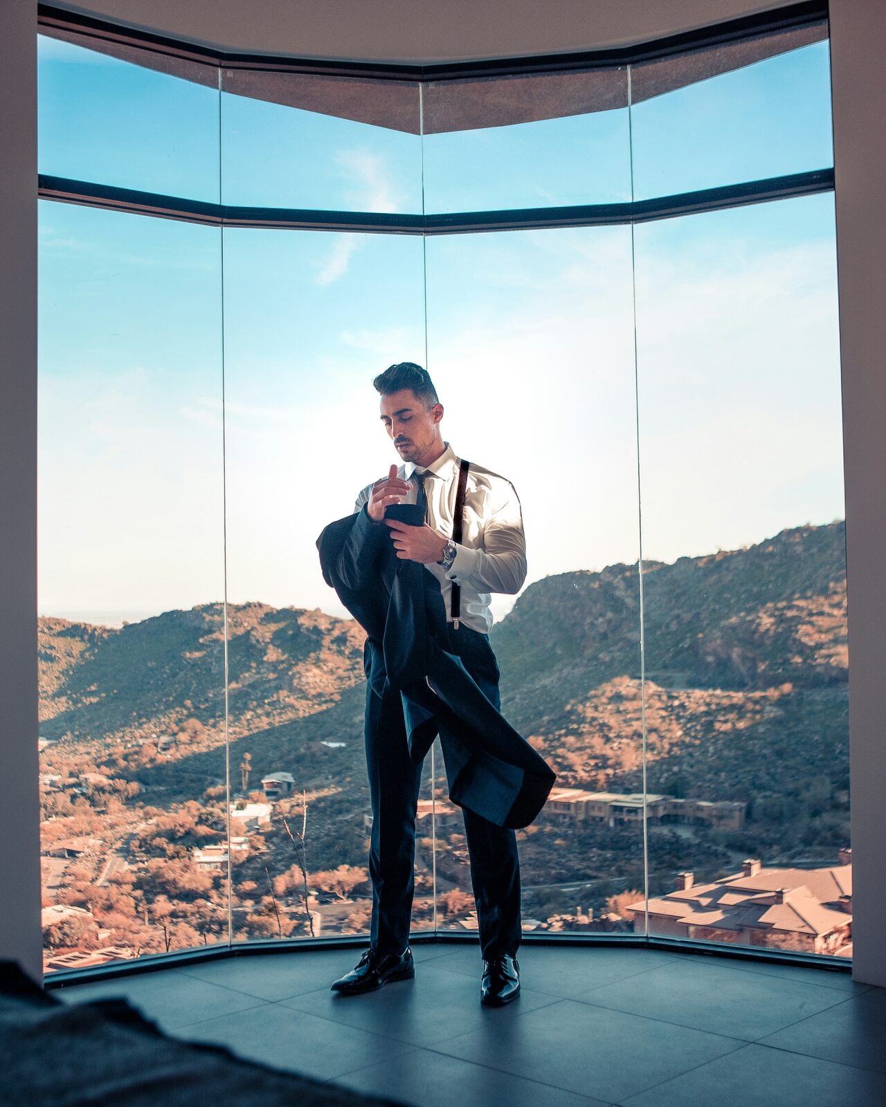 Arizona groom in a tuxedo getting ready with a mountain view while reviewing his prenup requirements