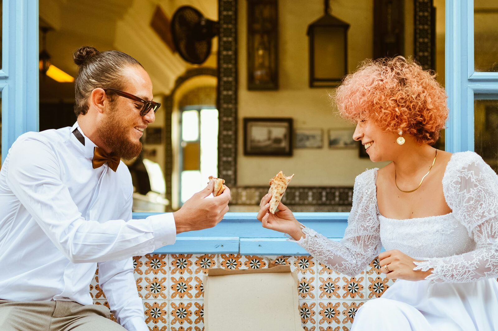 Newlyweds sharing pizza in a fun wedding portrait while exploring their Nevada prenup options