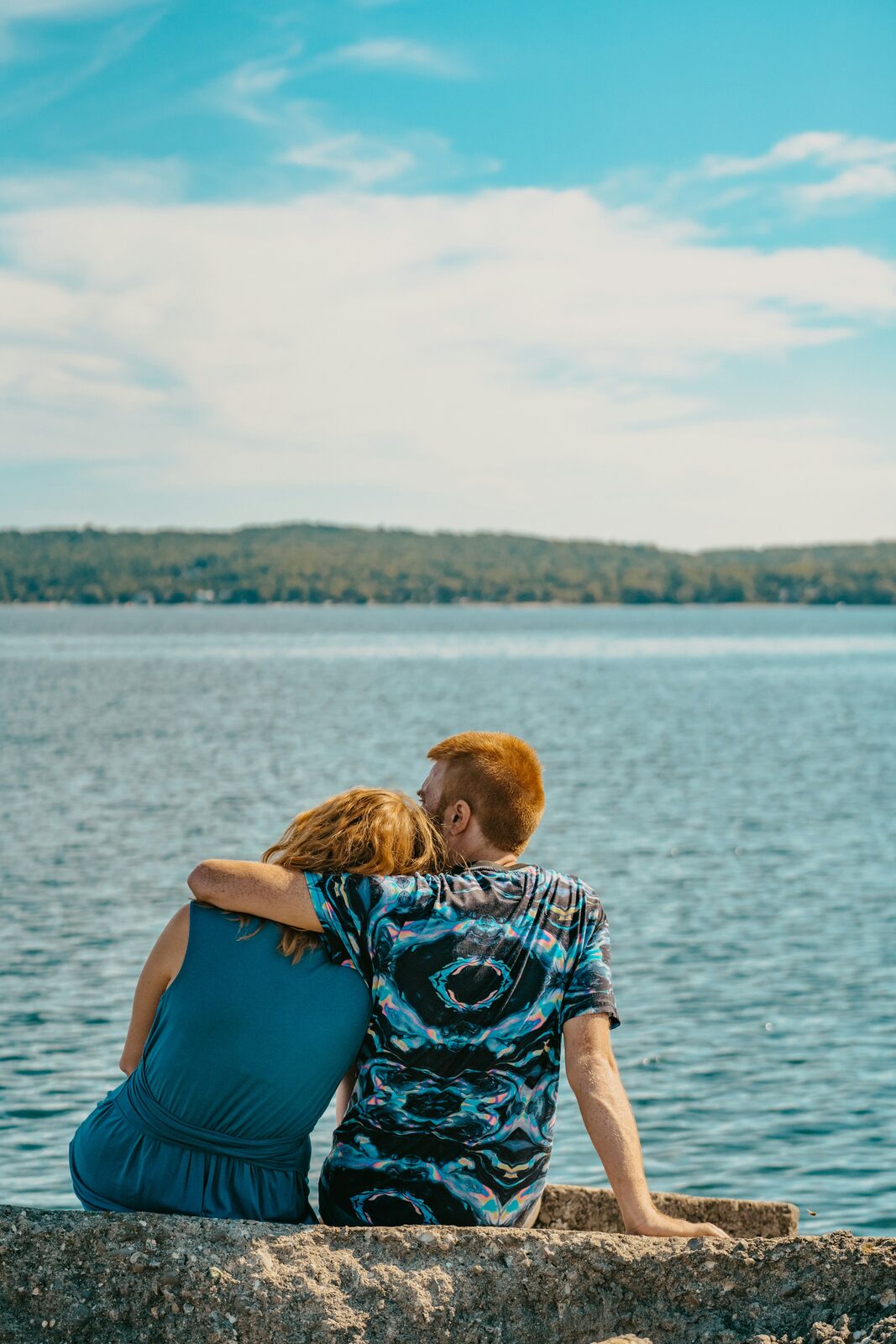 Michigan couple sitting on a rock overlooking the lake, exploring their prenup options