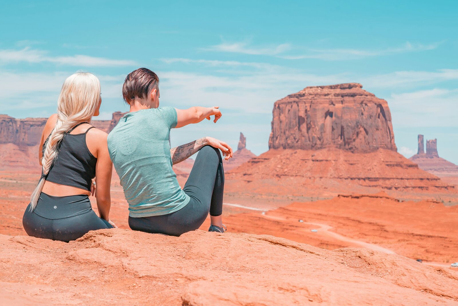 Two friends pointing across Monument Valley's red rocks in Arizona while considering what a prenup can include