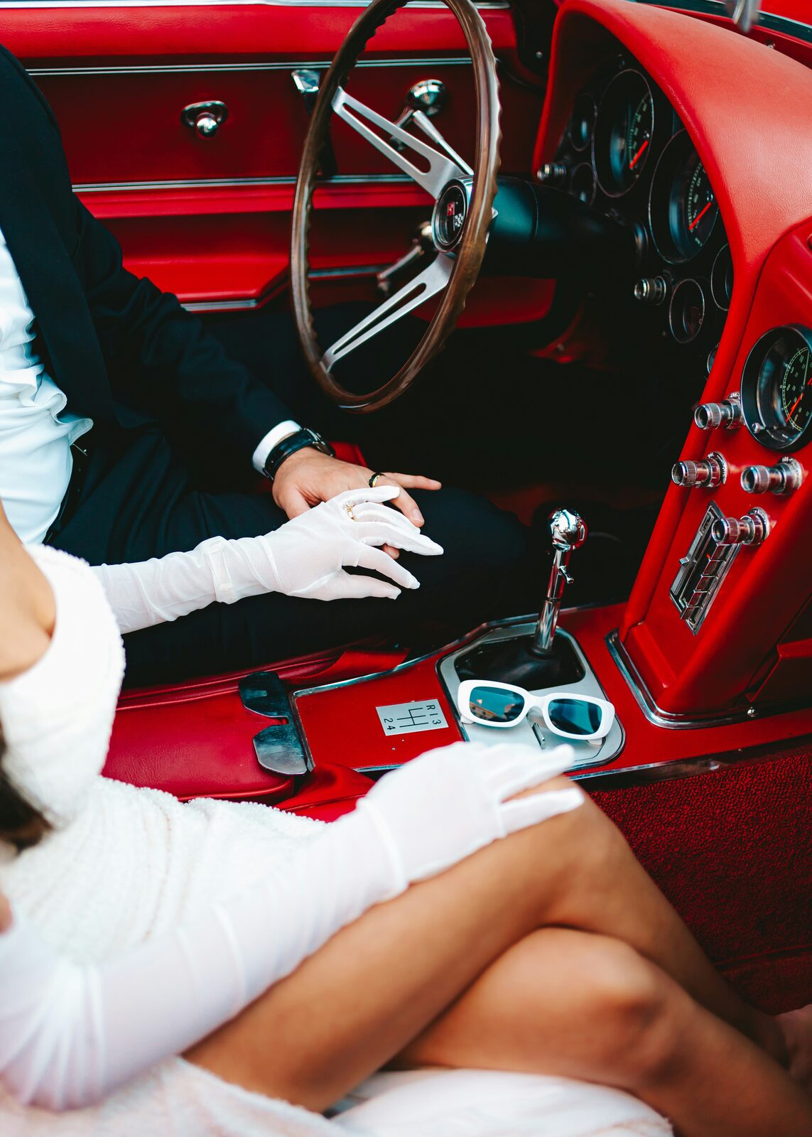 Newlywed couple in a vintage red Corvette getaway car after signing their Nevada prenup