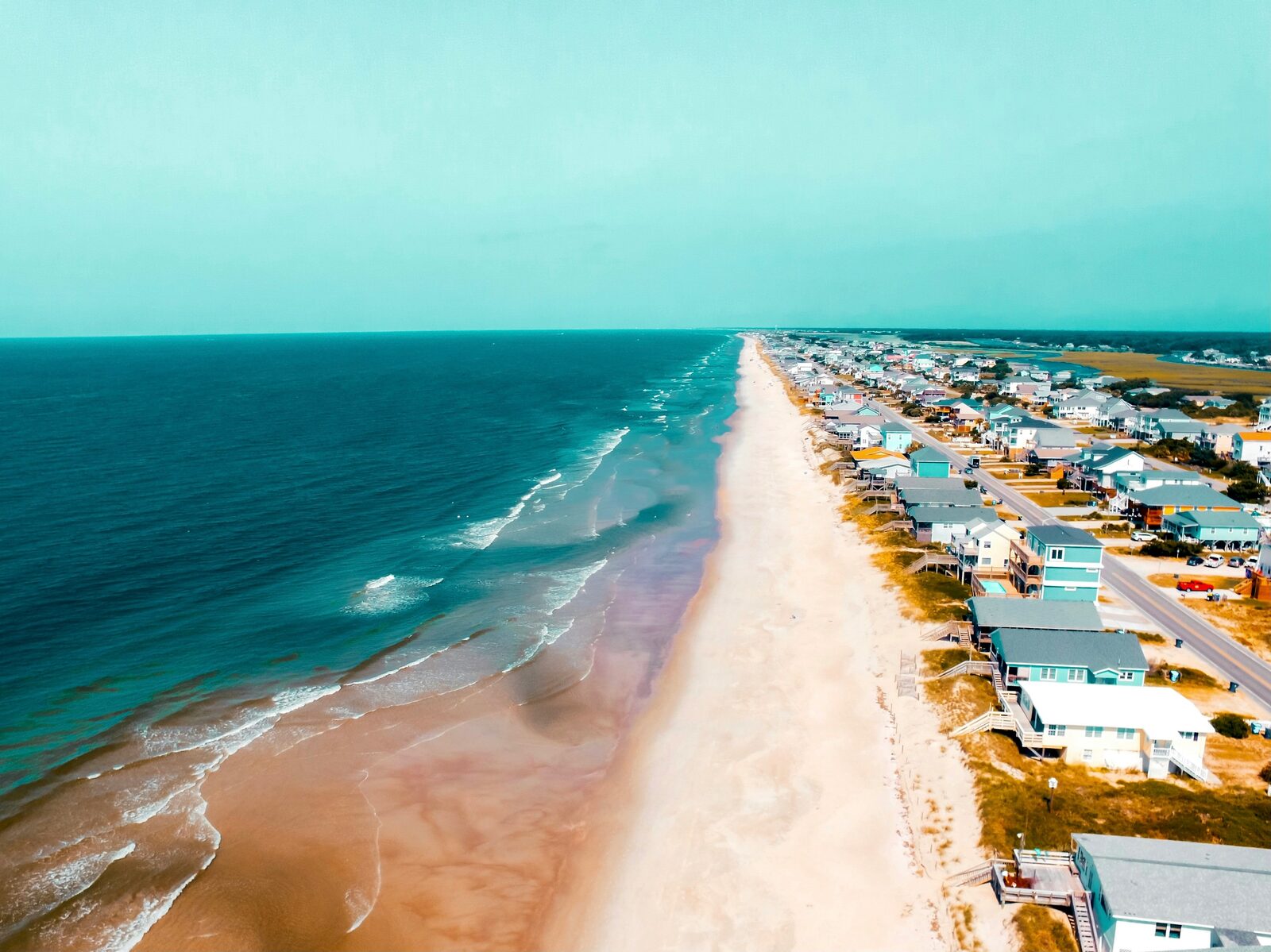 Aerial view of a pastel beach town on the North Carolina Outer Banks along the Atlantic coast