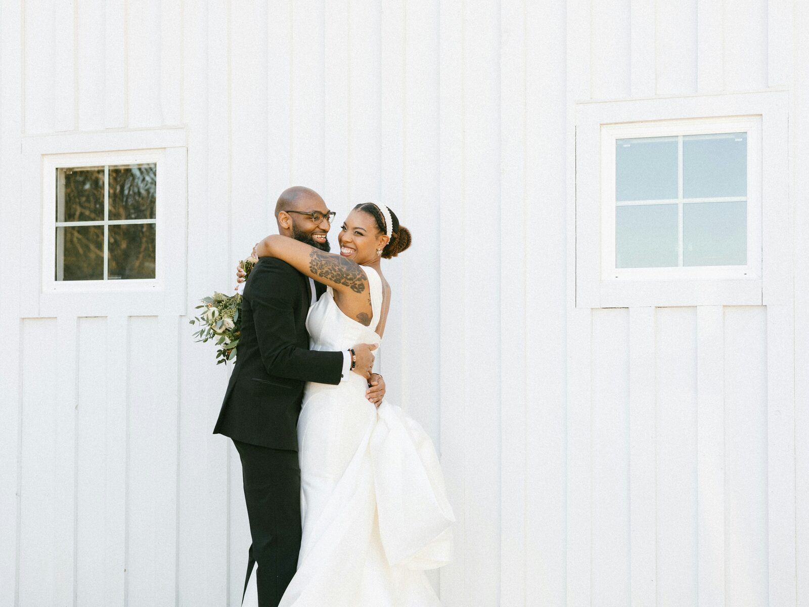 Maryland newlyweds embracing at their white barn wedding