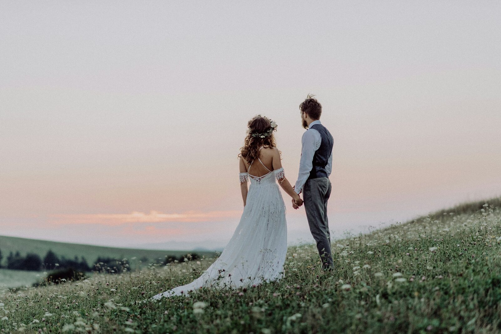 Ohio couple holding hands in a wildflower meadow at sunset